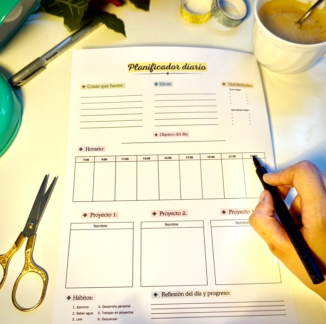 Planificador diario de Triunfonline en versión blanco y negro sobre mesa