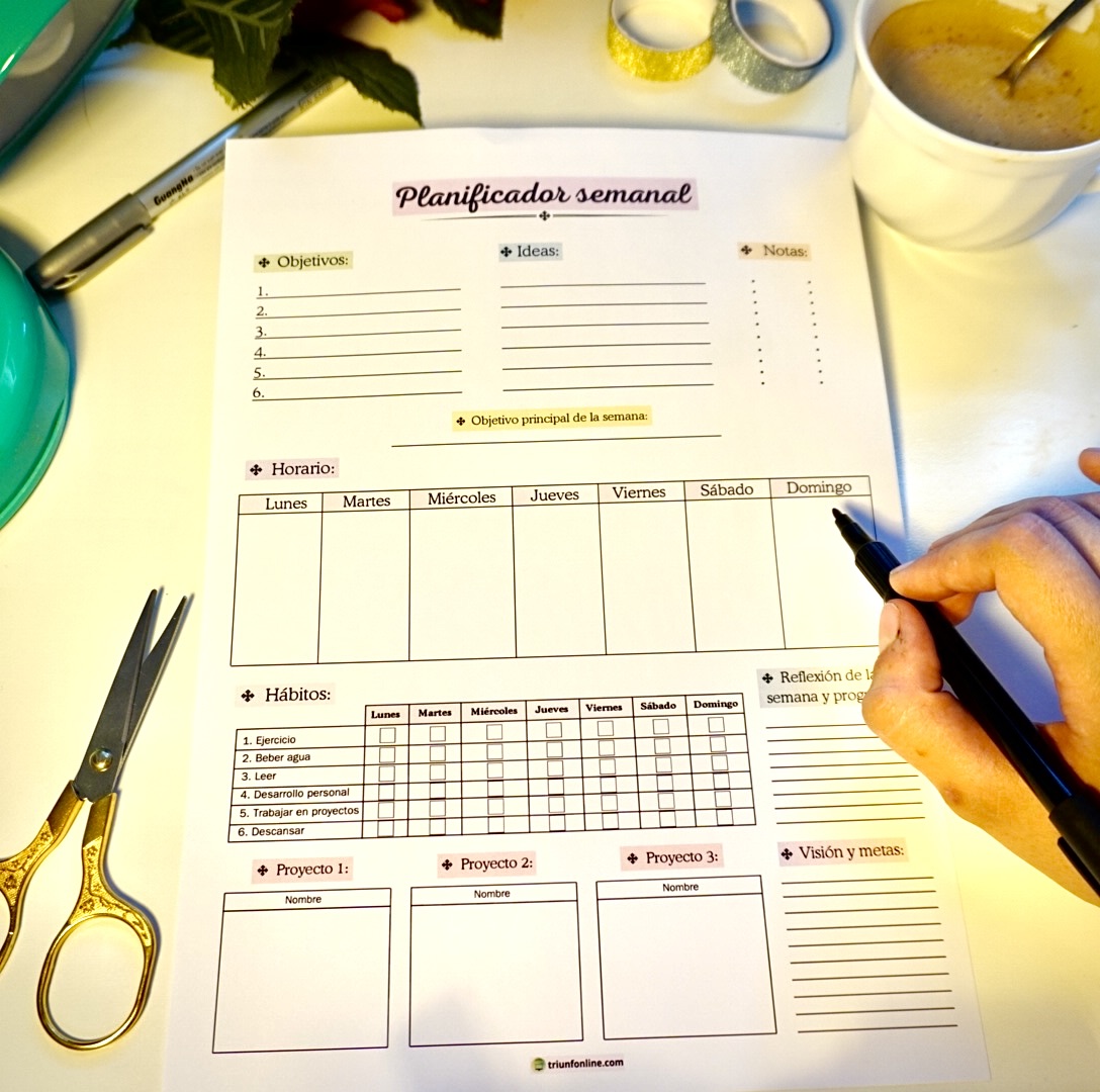 Mano escribiendo sobre el planificador semanal imprimible