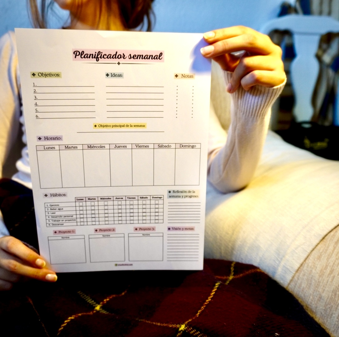 Mujer sosteniendo el planificador semanal imprimible